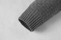 Close-up of grey men's hoodies sweater sleeve with knitted pattern and ribbed cuff