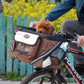 Bruine fietsmand voor huisdieren met reflecterende strepen en netzakken, geschikt voor kleine honden en katten, bevestigd aan het stuur van een fiets.