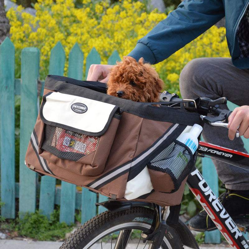 Bruine fietsmand voor huisdieren met reflecterende strepen en netzakken, geschikt voor kleine honden en katten, bevestigd aan het stuur van een fiets.