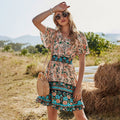 Vrouw draagt hoge taille V-hals jurk met korte mouwen en boho print in buitenomgeving