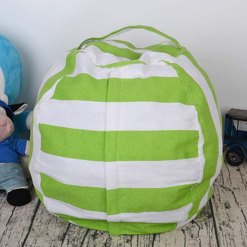 green and white striped canvas plush toy storage bag on wooden floor next to stuffed animal and toy car
