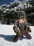 Dames tanktop met jarretels van spandex in winterse setting met jas en muts