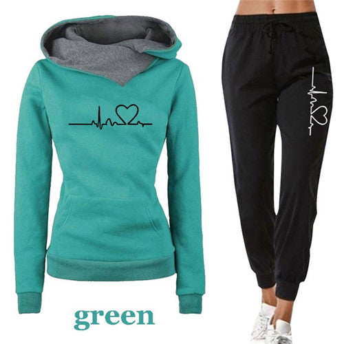 Green women tracksuit pullover hoodie with black pants featuring heartbeat heart design