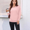 Women wearing pink loose pullover long sleeve autumn and winter top with black leggings holding coffee cup outdoors