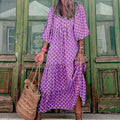 vrouwelijk zomerse dames vintage jurk met paars patroon en vleermuismouwen, bohemien stijl met rieten tas, buiten bij groene deur