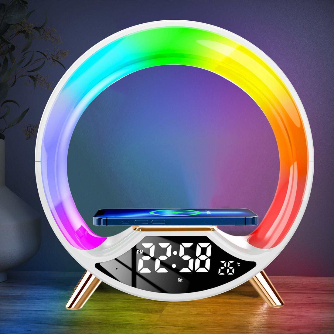 Wireless charging multifunctional Bluetooth speaker night light with colorful LED ring and digital clock display on bedside table