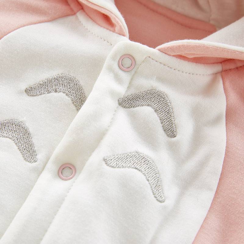 close-up katoenen baby romper met lange mouwen en capuchon, zachte roze en witte stof met cartoonprint