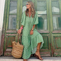 zomerse dames vintage groene jurk met bloemenmotief en lange mouwen gedragen door vrouw met zonnebril en woven tas
