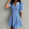 Blauwe bloemenjurk met hoge taille en witte revers, korte mouwen, A-lijn rok