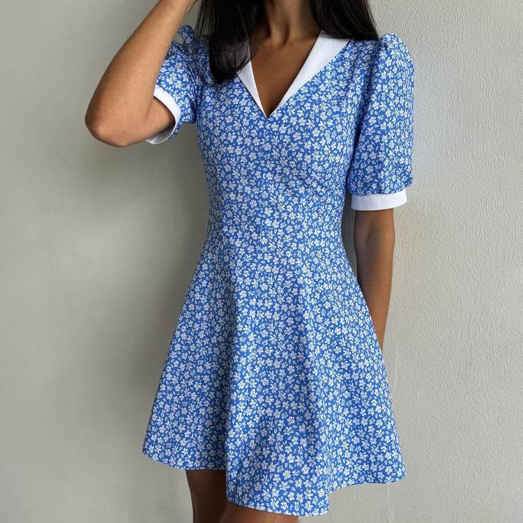 Blauwe bloemenjurk met hoge taille en witte revers, korte mouwen, A-lijn rok