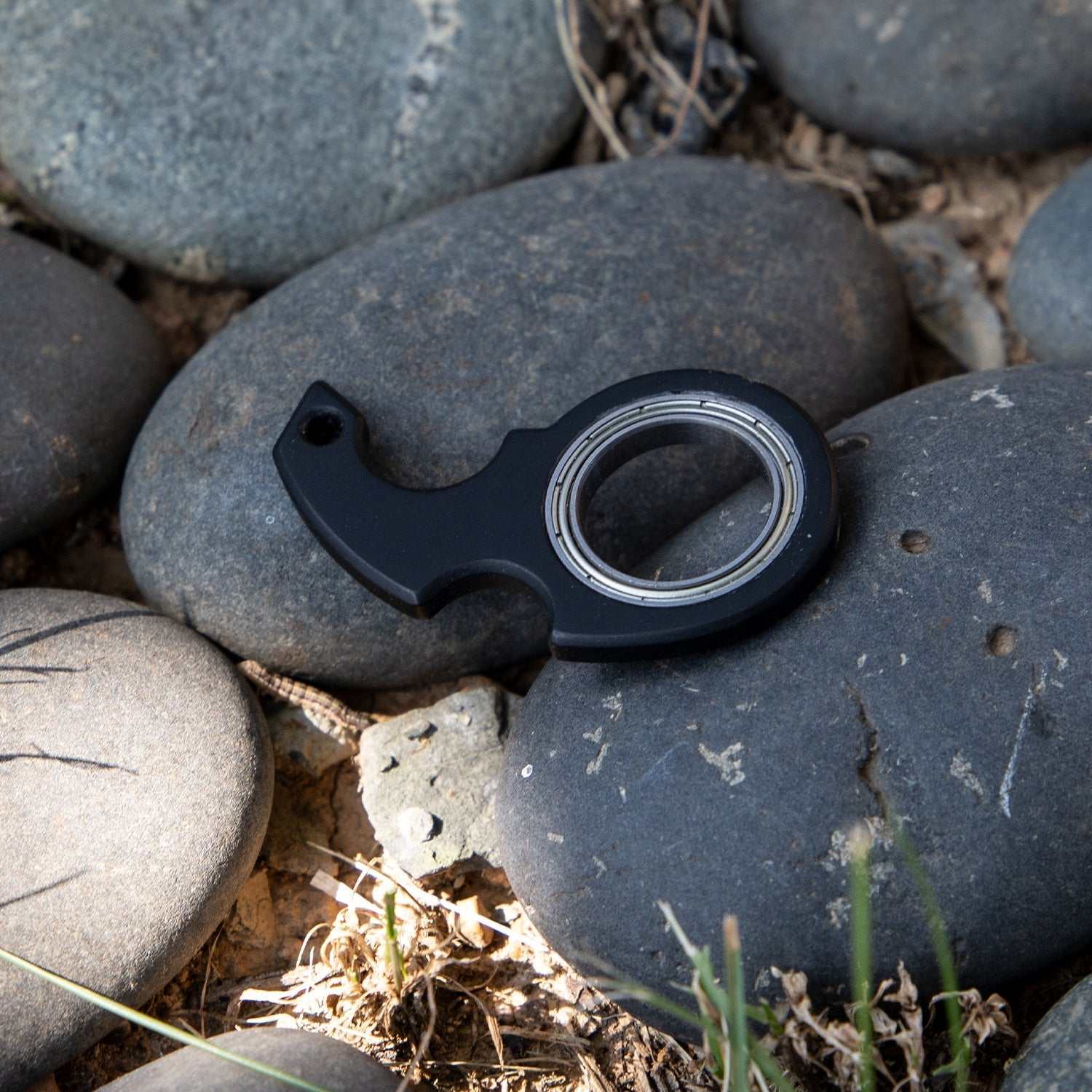 Zwarte fidget spinner speelgoed sleutelhanger van kunststof en zinklegering op stenen achtergrond