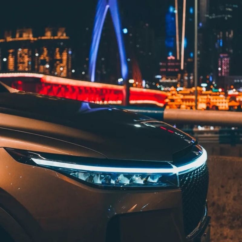 car front hood with sleek LED Daytime Running Light strip illuminated in blue at night