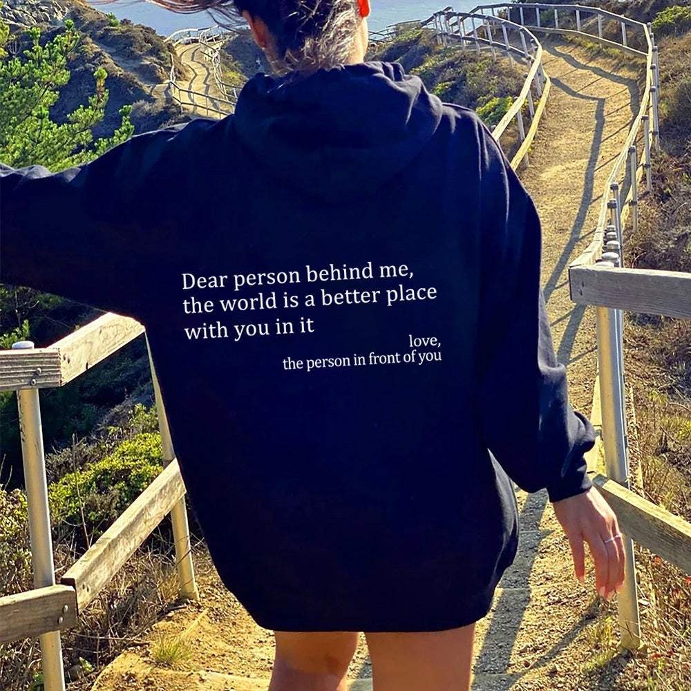 vrouw draagt zwarte dames hoodie met pluche letters en print wandelend buiten