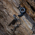 Zwarte sleutelhanger met Fidget Spinner speelgoed bevestigd op houten oppervlak, ideaal voor concentratie en ontspanning.