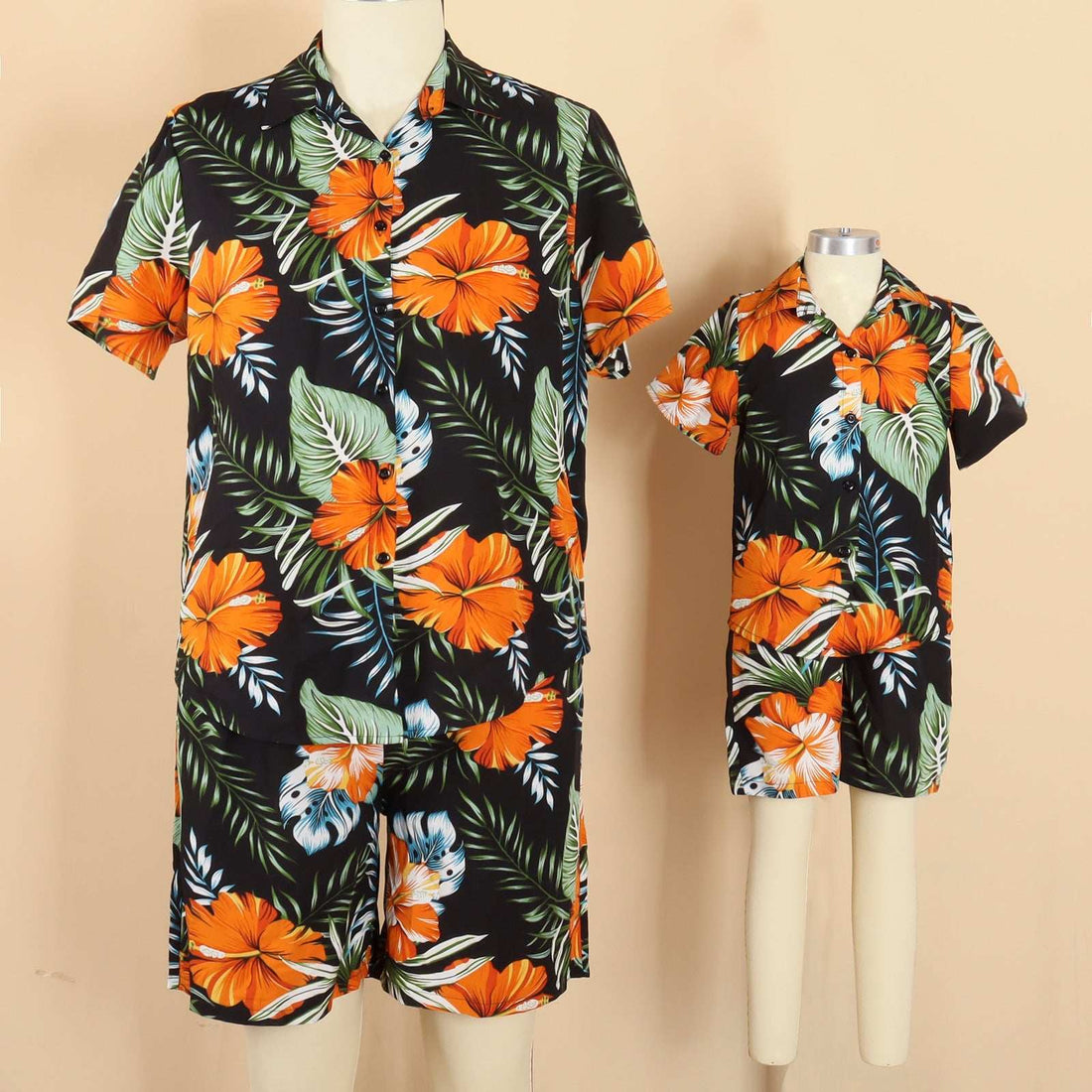 gezin van 4 vakantie reizen in bijpassende Hawaii ouder-kind kleding met oranje bloemenprint op het strand