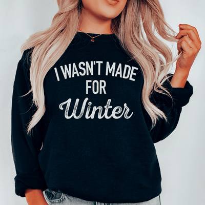 Black "I Wasn't Made For Winter" sweatshirt with cozy fleece lining and adjustable cuffs worn by blonde woman